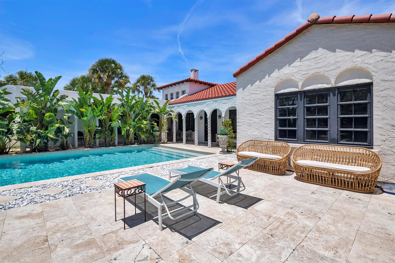 A swimming pool sits on a stone patio beside a white stucco house with arches — 333 Murray Road, West Palm Beach FL 33405, WEST PALM BEACH, FL