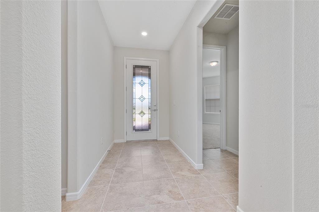 A tiled entryway features a white front door with a decorative glass insert — 13270 PANAMA BEACH COURT, ORLANDO, FL