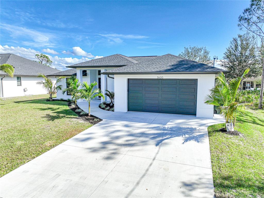 A single-story white house with a dark gray roof and a two-car garage — 3600 CINCINNATI STREET, NORTH PORT, FL