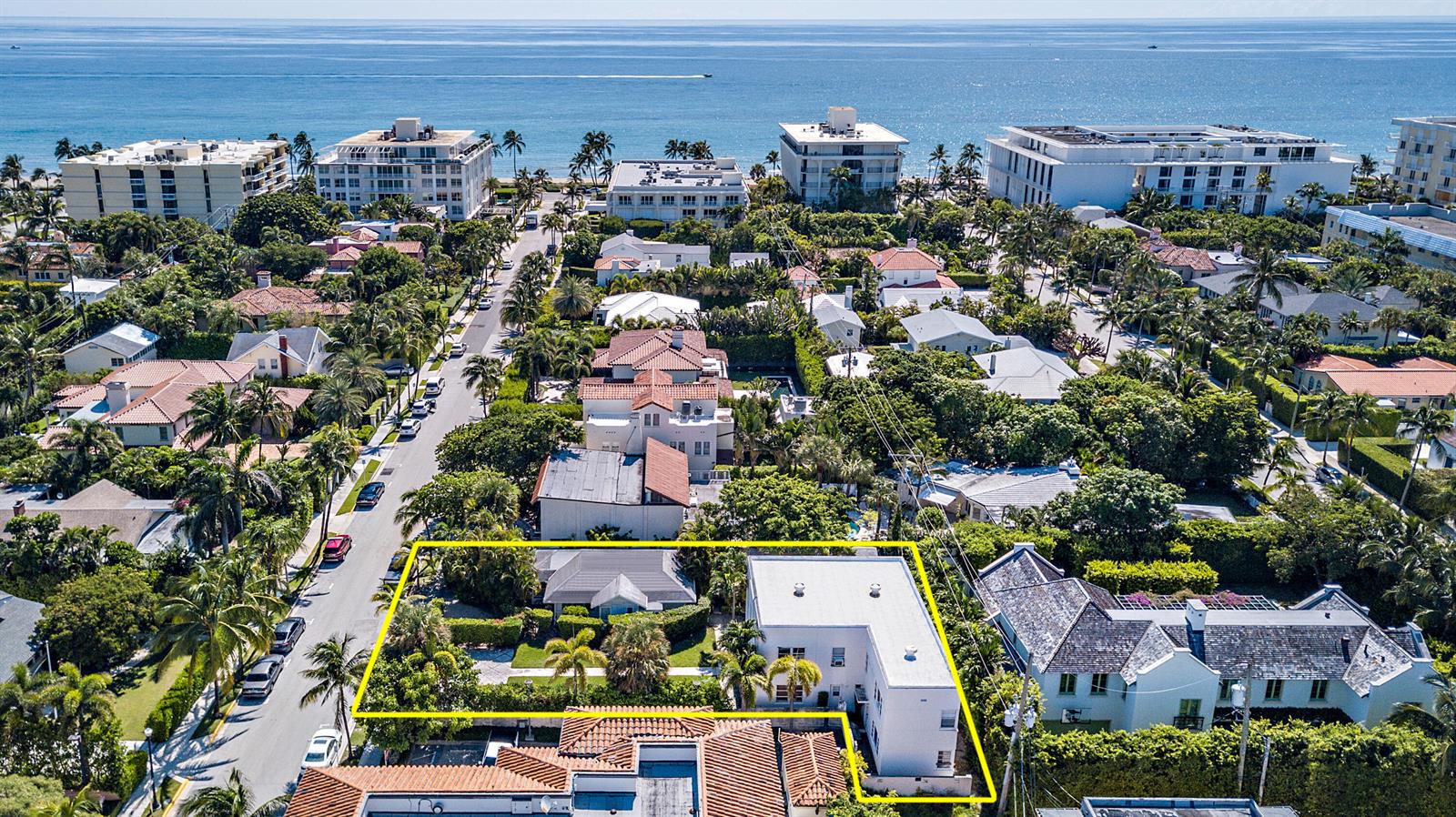 An aerial view shows a residential property with two buildings surrounded by lush tropical landscaping — 150 Australian Avenue, Palm Beach FL 33480, PALM BEACH, FL