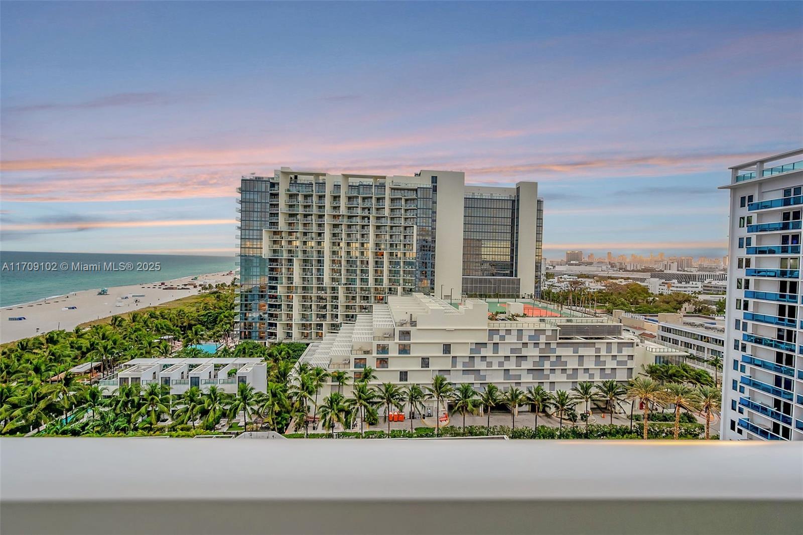 An elevated view of a coastal resort complex with a beach and tennis courts — 2301 Collins Ave # 1206, Miami Beach FL 33139, MIAMI BEACH, FL
