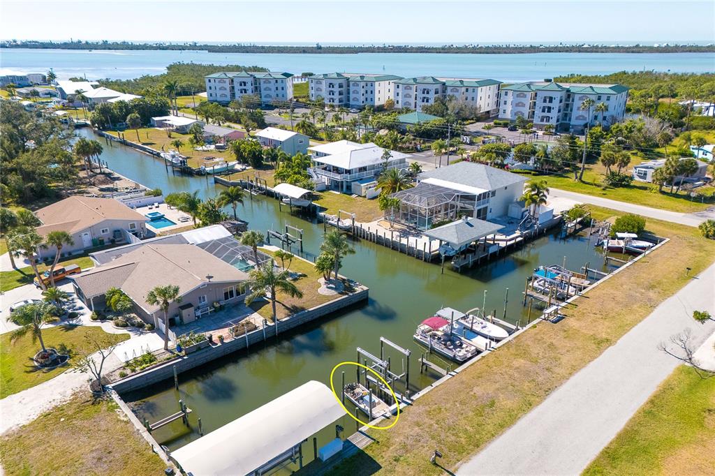 An aerial view shows a canal-front property with a boat lift and dock — 9080 GRIGGS ROAD, ENGLEWOOD, FL