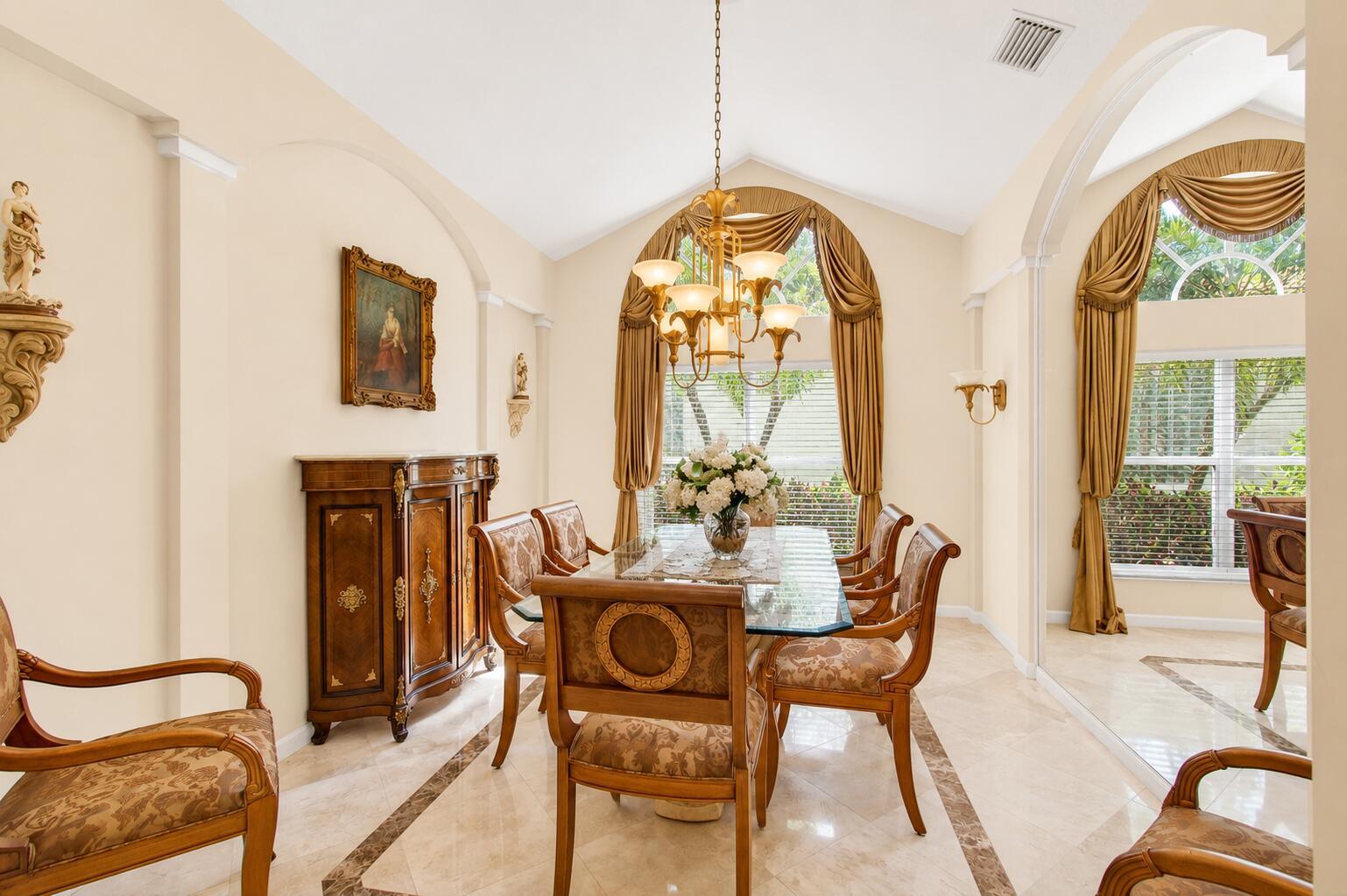 A formal dining room features a glass-topped table, ornate wooden chairs, and arched windows — 6850 Fiji Circle, Boynton Beach FL 33437, BOYNTON BEACH, FL