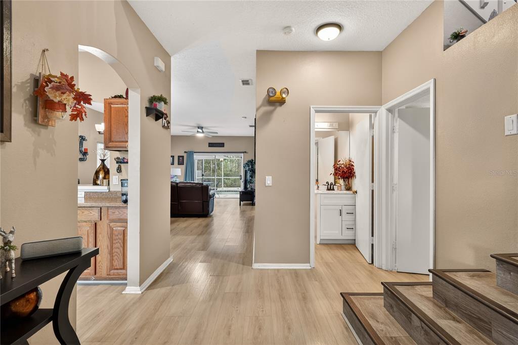 A foyer with wood-look flooring leads to a living area, a kitchen, and a bathroom — 13230 MEADOWFIELD DR, ORLANDO, FL