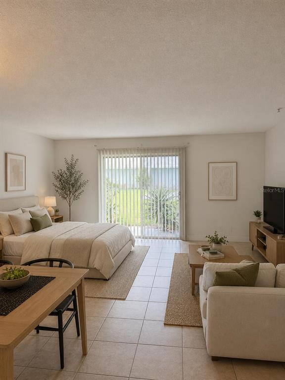 A studio apartment features a bed, living area, dining table, and sliding glass patio doors — 4251 NW 5TH STREET UNIT 121, FORT LAUDERDALE, FL