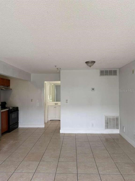 A tiled room features a kitchen area on the left and a doorway leading inside — 4251 NW 5TH STREET UNIT 121, FORT LAUDERDALE, FL