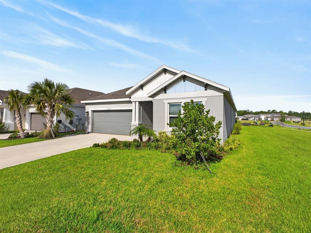 A single-story suburban house with a gray exterior, a two-car garage, and a front lawn — 4666 ACKEE ROAD, KISSIMMEE, FL