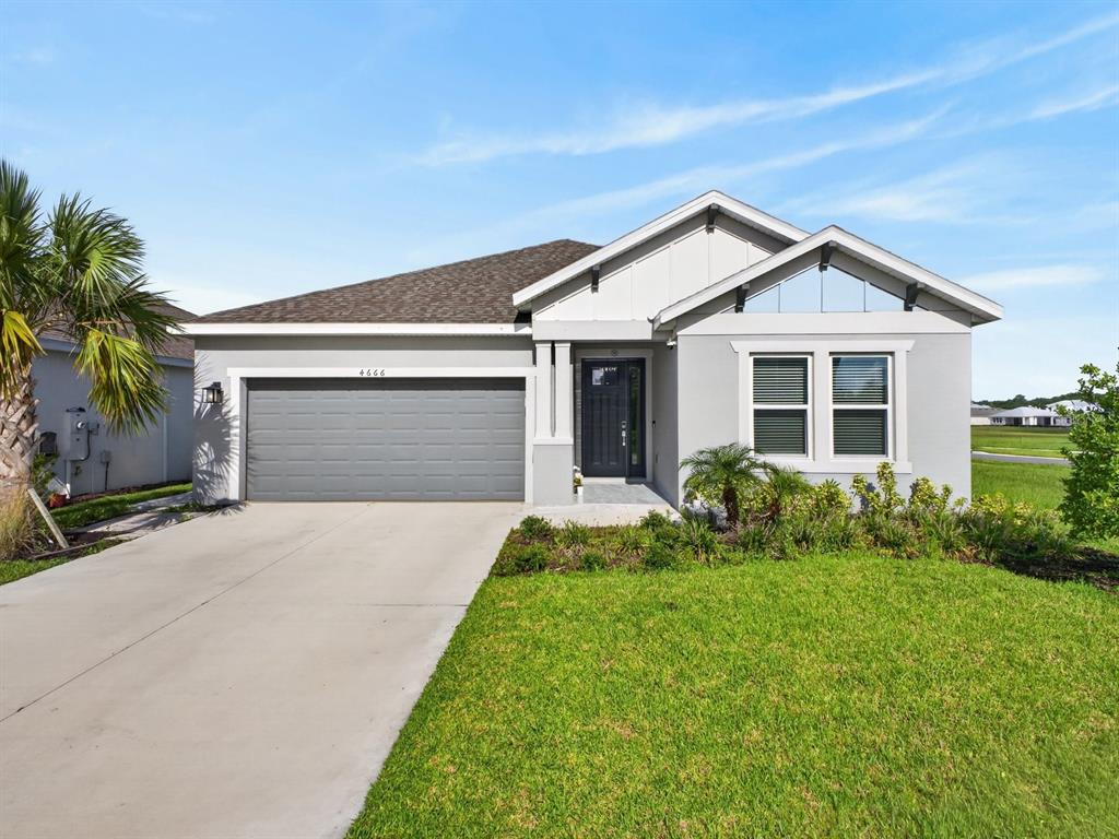 A single-story house with a gray garage, white trim, and a front-facing entrance — 4666 ACKEE ROAD, KISSIMMEE, FL