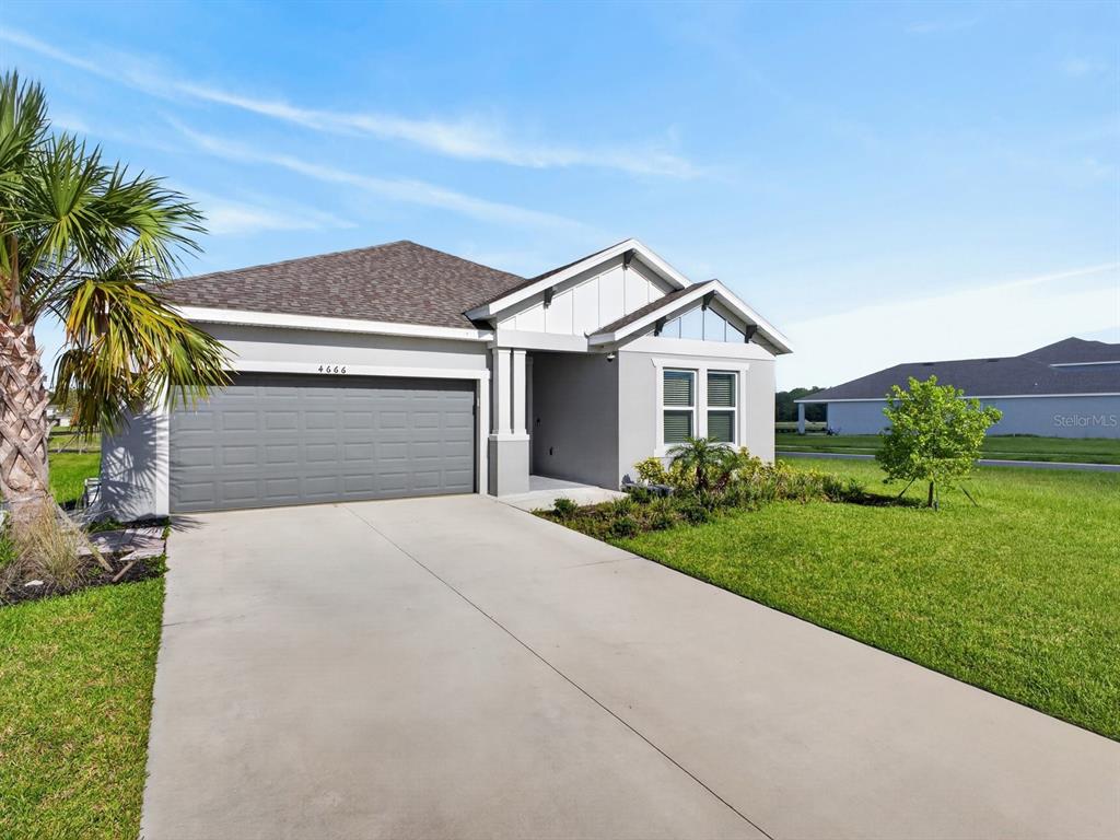 A single-story house with a gray garage, white trim, and a concrete driveway — 4666 ACKEE ROAD, KISSIMMEE, FL