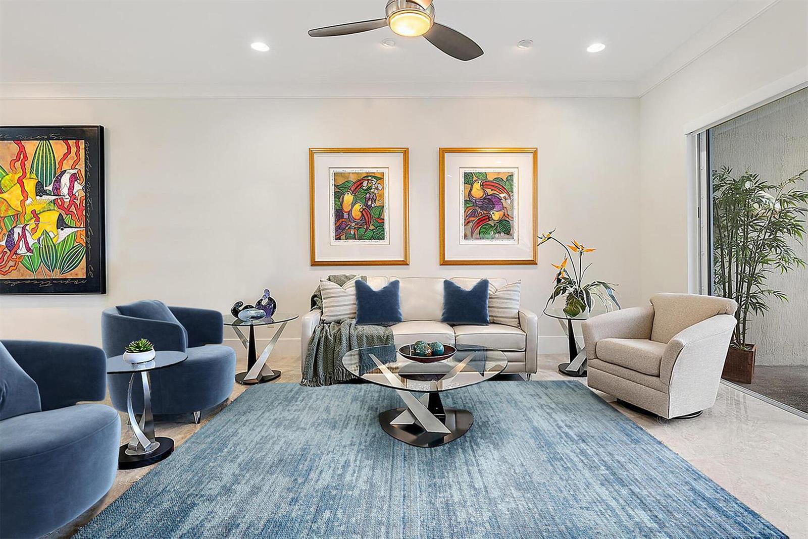 A living room features a blue area rug, a white sofa, and colorful framed artwork — 138 Tierra Lane # 6, Jupiter FL 33477, JUPITER, FL