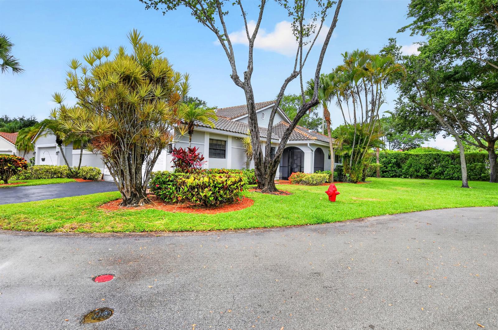 A single-story house with a tiled roof, palm trees, and a fire hydrant on the lawn — 10523 Ladypalm # B, Boca Raton FL 33498, BOCA RATON, FL