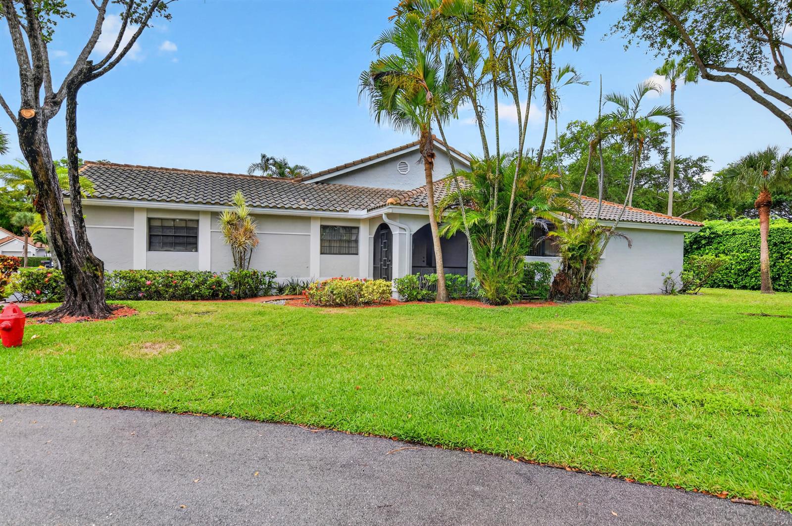 A single-story house with a tiled roof, gray exterior, and palm trees in the front yard — 10523 Ladypalm # B, Boca Raton FL 33498, BOCA RATON, FL
