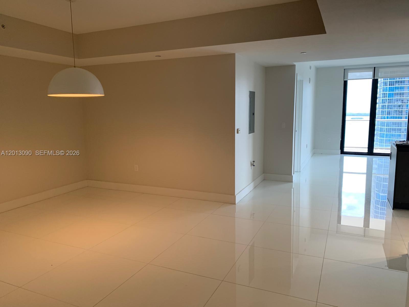 An empty room with white tile floors, a ceiling fan, and a sliding glass door — 1010 Brickell Ave # 3704, Miami FL 33131, MIAMI, FL