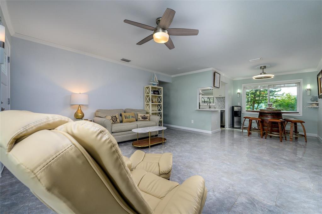 A living room features a beige recliner, a sofa, a dining area, and tiled floors — 1472 QUEEN ANNE DRIVE, PALM HARBOR, FL