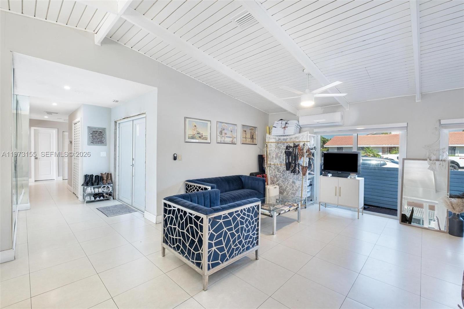 A living room features white tile floors, a vaulted ceiling, and blue patterned furniture — 13710 SW 18th Ter, Miami FL 33175, MIAMI, FL