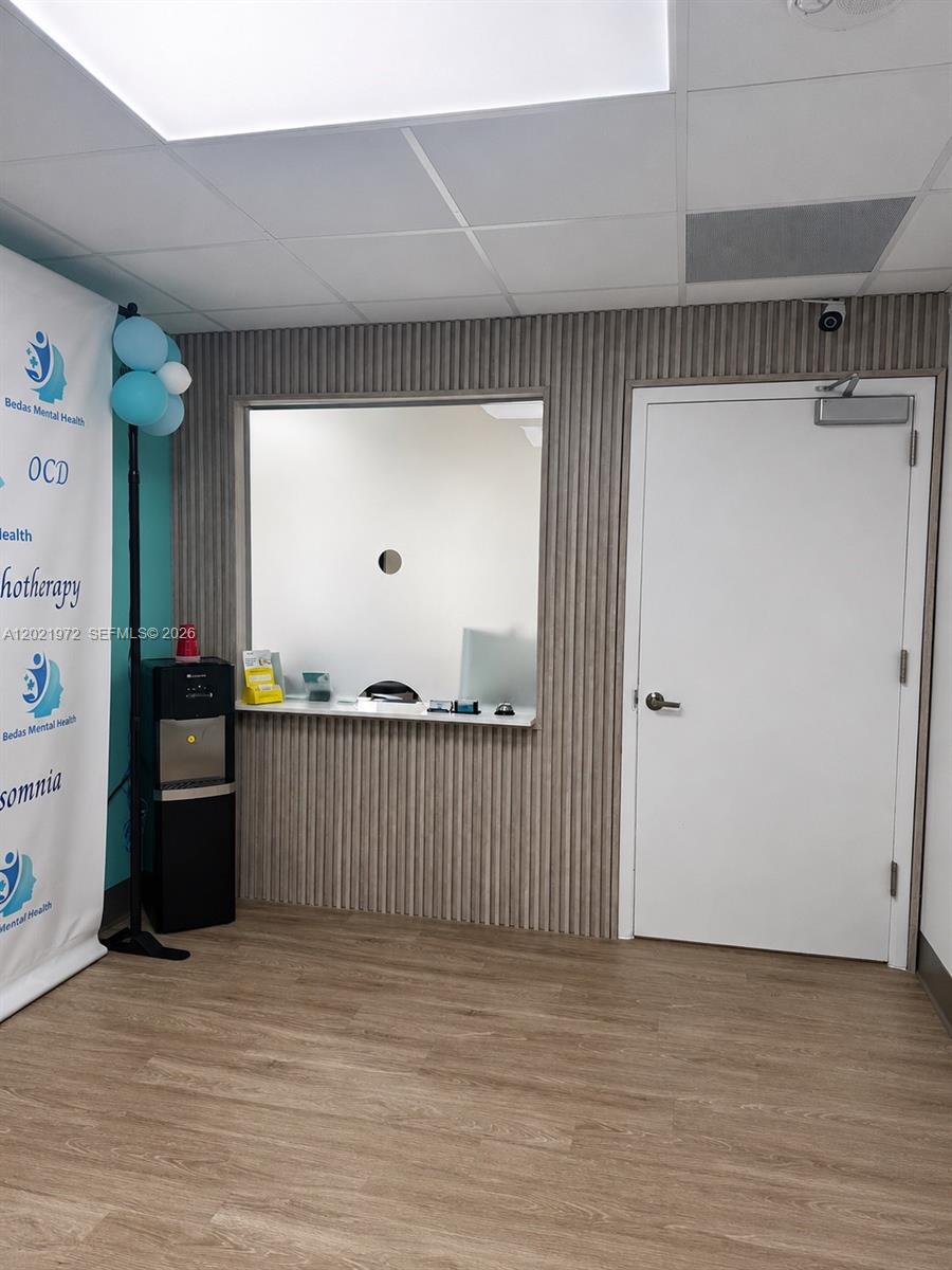 A reception area features a service window, a water cooler, and a white door — 7100 W 20th Ave # 214, Hialeah FL 33016, HIALEAH, FL
