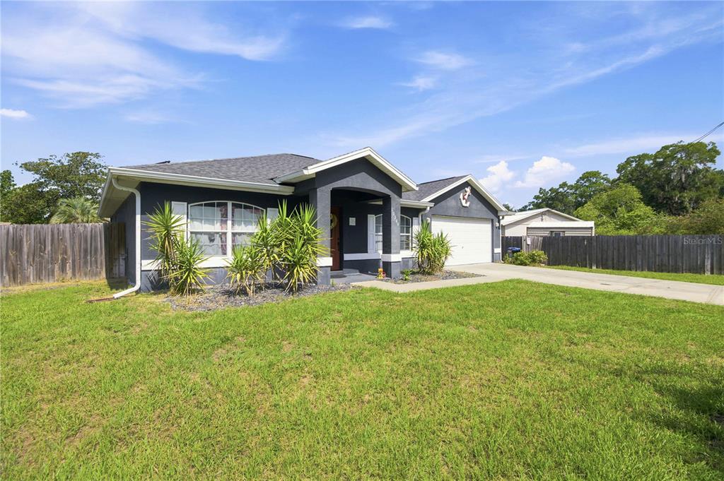 A single-story house with dark gray siding, a two-car garage, and a front lawn — 10544 SE 54TH AVENUE, BELLEVIEW, FL