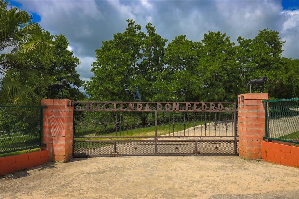 A metal gate with the name Hacienda Don Pedro sits between two brick pillars — 150 CARR UNIT 10.8km, VILLALBA, PR