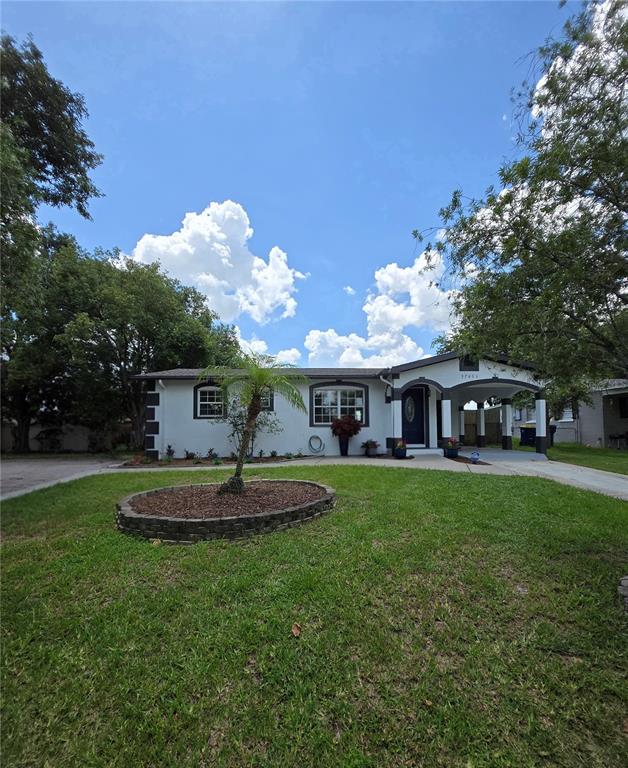 A single-story house with a white exterior, dark trim, and a front carport — 37406 VISTA DRIVE, DADE CITY, FL