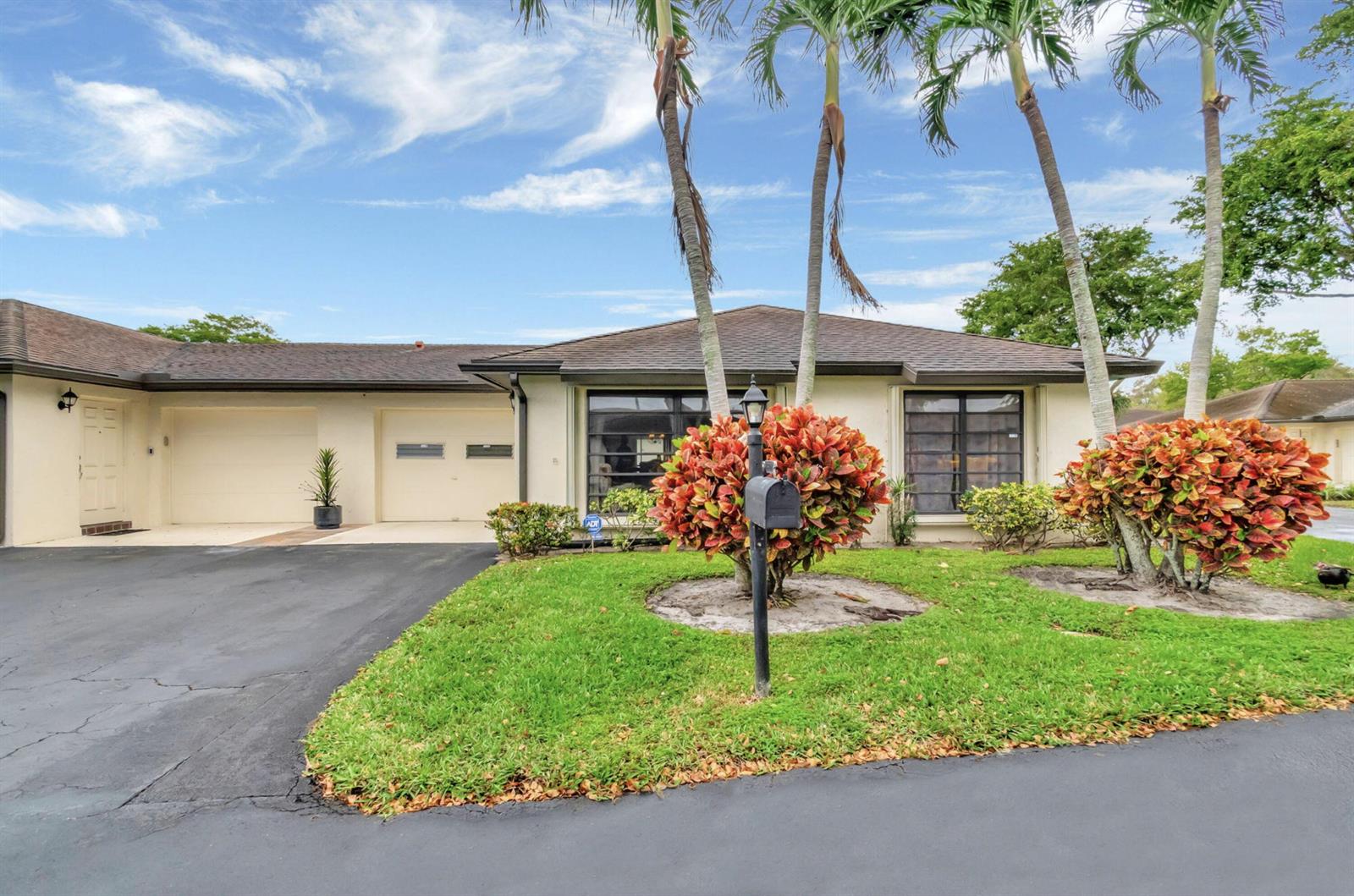 A single-story house with a two-car garage, palm trees, and landscaping in the front yard — 4660 Greentree Place # 105b, Boynton Beach FL 33436, BOYNTON BEACH, FL