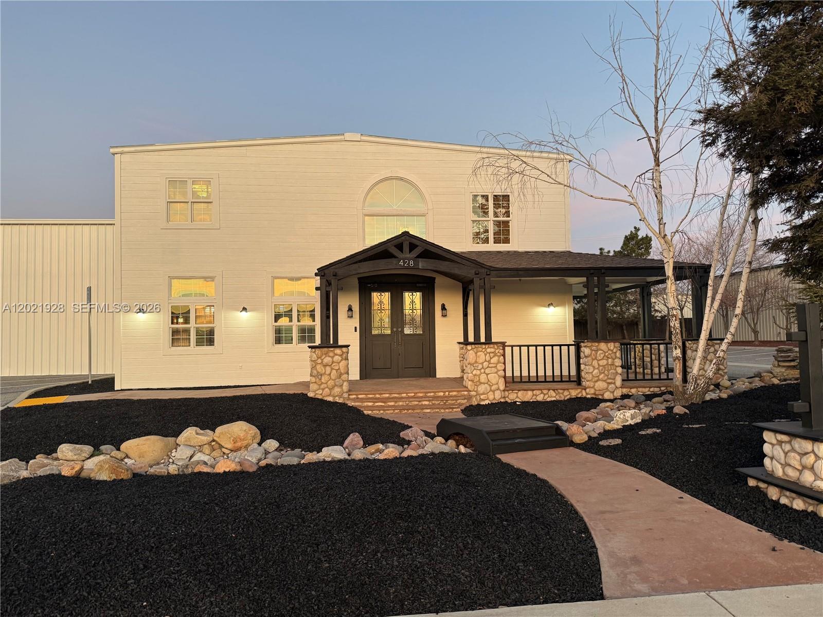 A two-story white building features a dark covered porch with stone pillars and black railings — 428 N Curry Street, CA 93561, CA