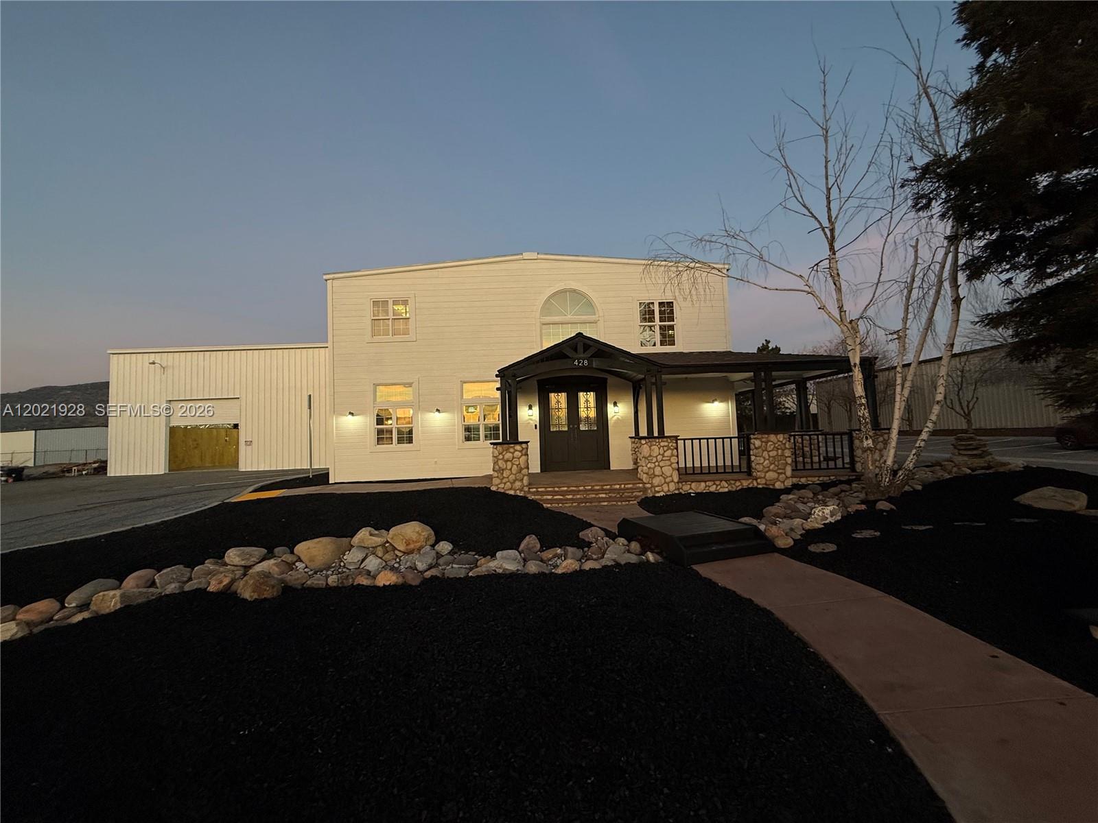 A two-story white building with a stone-accented porch and an attached metal warehouse — 428 N Curry Street, CA 93561, CA