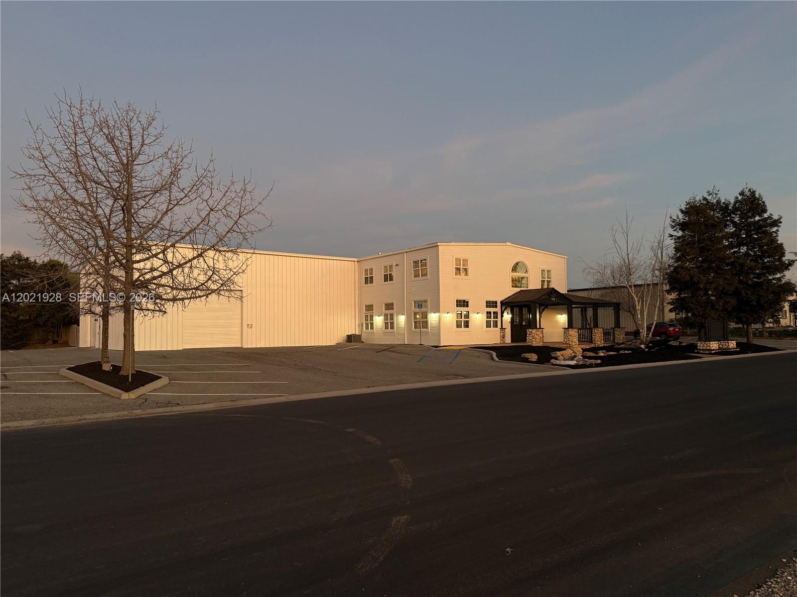 A two-story commercial building with a large attached warehouse sits beside a paved parking lot — 428 N Curry Street, CA 93561, CA