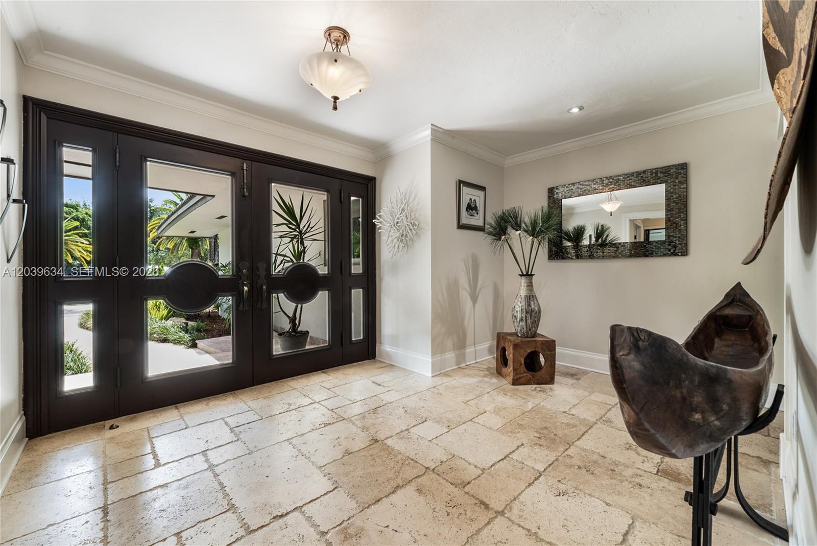 An entryway features a dark double door, stone tile flooring, and a decorative wooden sculpture — 11900 SW 63rd Ave, Pinecrest FL 33156, PINECREST, FL