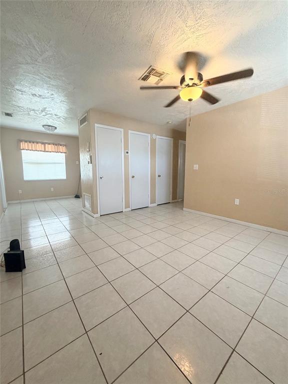 A room with light-colored tile flooring, white doors, and a ceiling fan — 5425 KAREN COURT, ORLANDO, FL