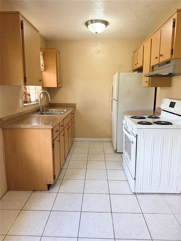 A kitchen with light wood cabinets, white appliances, and white tile flooring — 5425 KAREN COURT, ORLANDO, FL