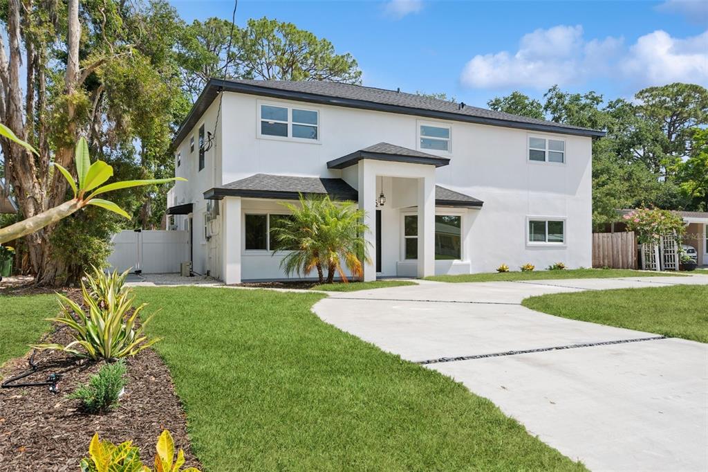 A two-story white house with a dark roof and a concrete driveway in front — 2655 BAY STREET, SARASOTA, FL