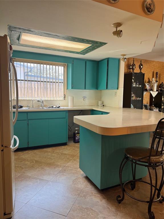 A kitchen features turquoise cabinets, a white countertop, and a tiled floor — 9201 BARRINGTON LANE, PORT RICHEY, FL