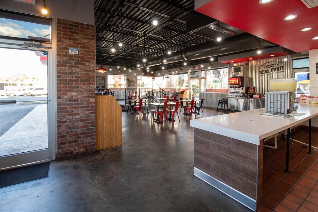 A restaurant interior features a brick wall, concrete floors, red chairs, and a service counter — 5908 S ORANGE BLOSSOM TRAIL, ORLANDO, FL