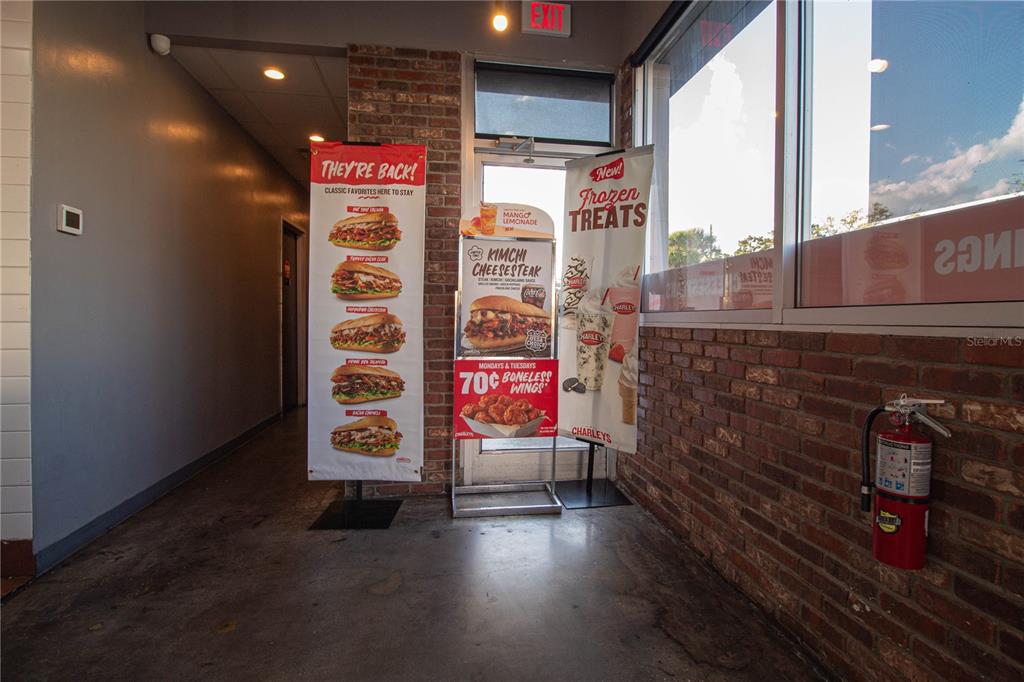 A commercial interior features brick walls, a concrete floor, promotional signage, and a fire extinguisher — 5908 S ORANGE BLOSSOM TRAIL, ORLANDO, FL