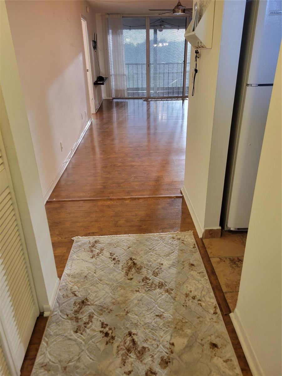 A view from a tiled entryway looking into a living area with wood-look flooring — 3671 Environ Boulevard # 468, Lauderhill FL 33319, LAUDERHILL, FL