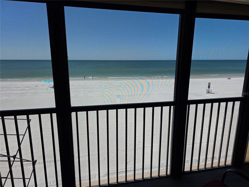 A view of a sandy beach and ocean from a screened-in balcony — 17580 GULF BOULEVARD UNIT 311, REDINGTON SHORES, FL
