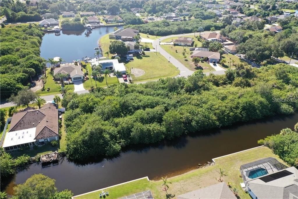 An aerial view shows houses situated along a canal and a small lake — 17404 PHEASANT CIRCLE, PORT CHARLOTTE, FL