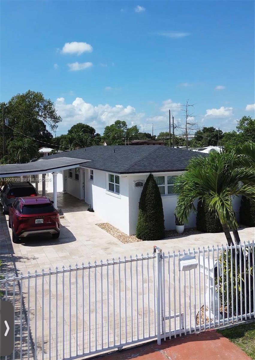 A white single-story house with a dark roof, a carport, and a paved driveway — 2512 NW 68th St, Miami FL 33147, MIAMI, FL