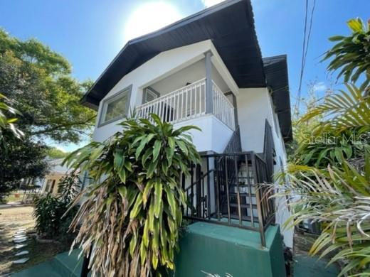 A two-story house with a white exterior, a front balcony, and a white picket fence — 1211 1/2 E 17TH AVENUE, TAMPA, FL
