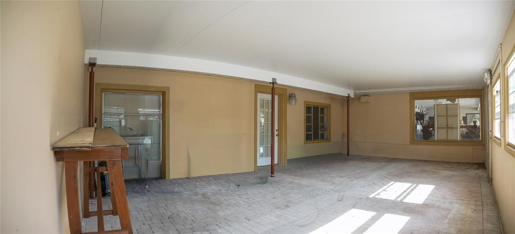 A covered patio with a brick floor, beige walls, and a wooden workbench — 1220 CLEARWATER LARGO ROAD N, LARGO, FL