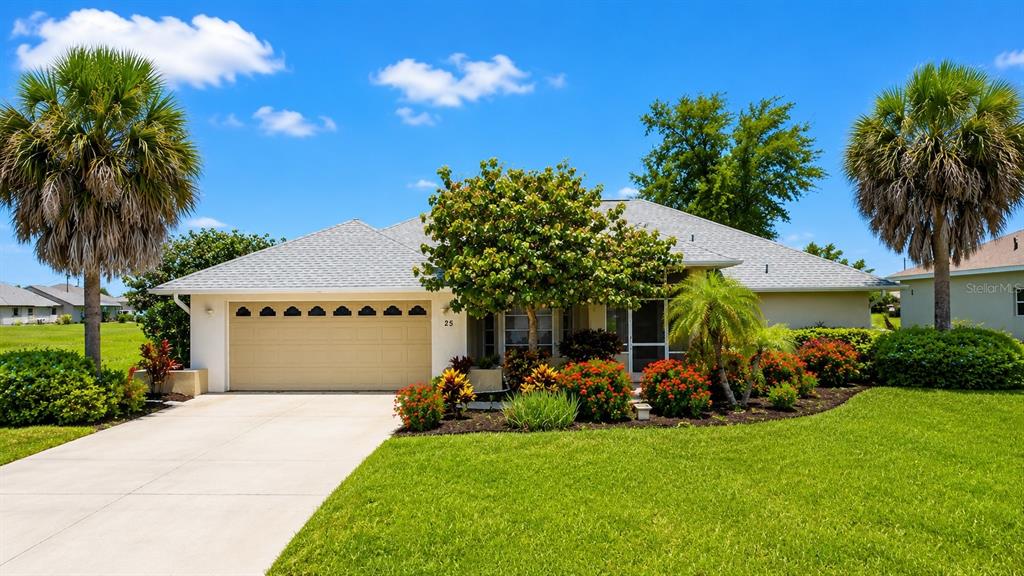 A single-story house with a beige garage and a front yard with palm trees — 25 FAIRWAY ROAD, ROTONDA WEST, FL