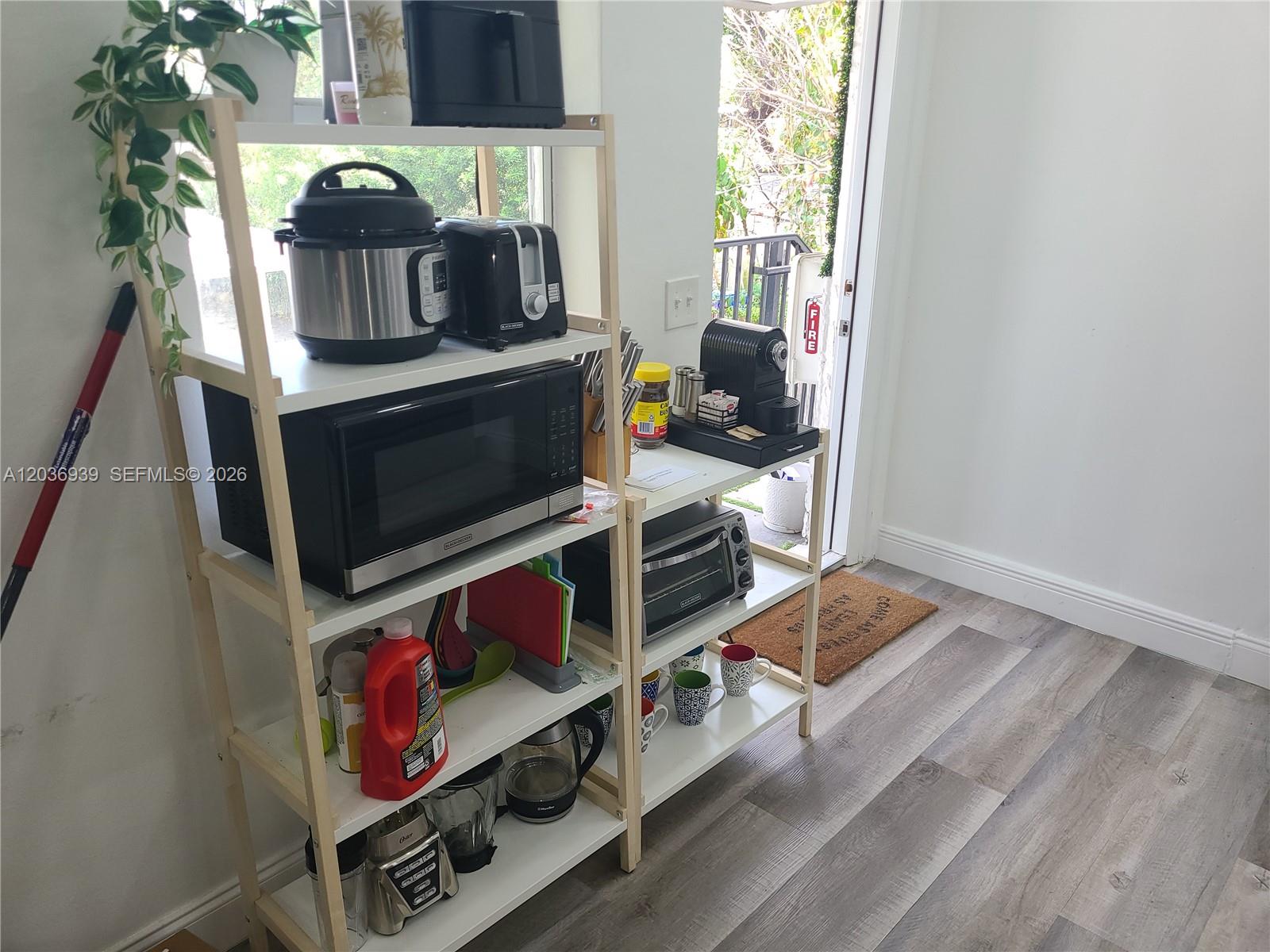 A kitchen area features two white shelving units holding various small appliances and kitchenware — 168 NW 32nd St # 6, Miami FL 33127, MIAMI, FL
