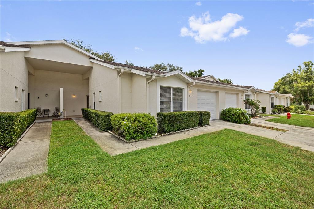 A row of single-story residential units with attached garages, covered entryways, and manicured landscaping — 8407 TERRACE MEADOWS COURT UNIT N/A, TAMPA, FL