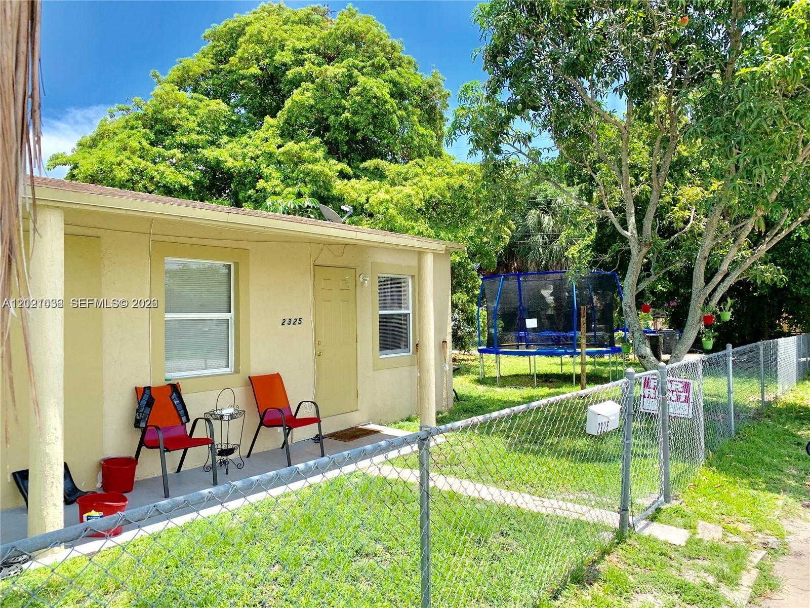 A single-story house with a chain-link fence, a front porch, and a backyard trampoline — 2325 N 25th Ave # 2325, Hollywood FL 33020, HOLLYWOOD, FL