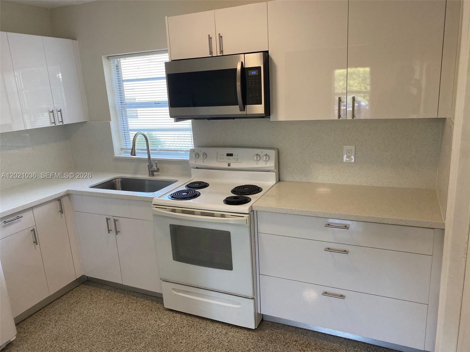 A kitchen features white cabinets, a stainless steel microwave, a white stove, and light countertops — 2325 N 25th Ave # 2325, Hollywood FL 33020, HOLLYWOOD, FL