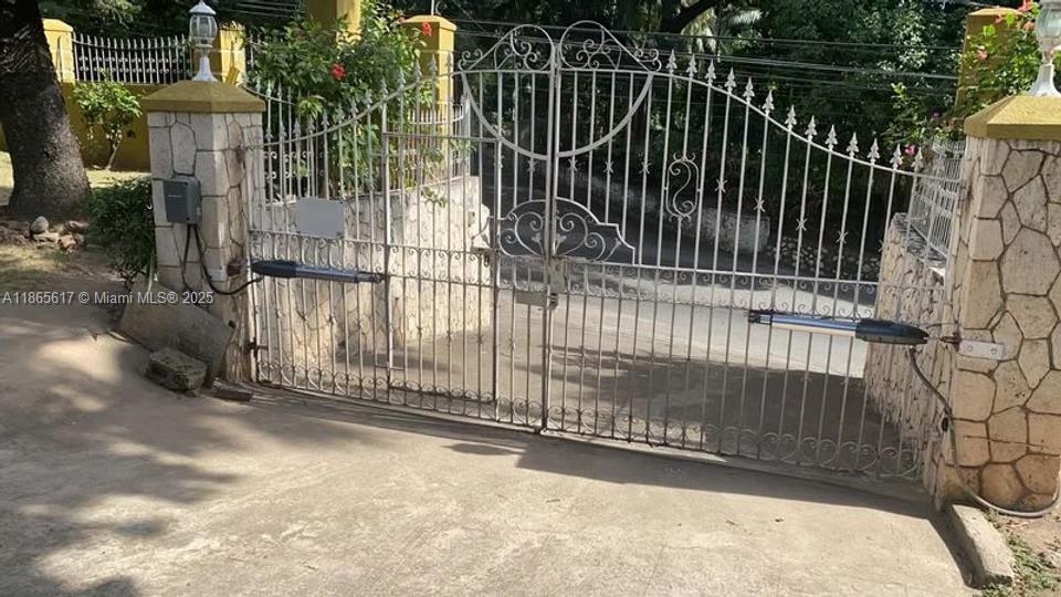 A white metal gate with automatic openers is set between two stone pillars — 00 Stony Hill, Kingston, NA, NA