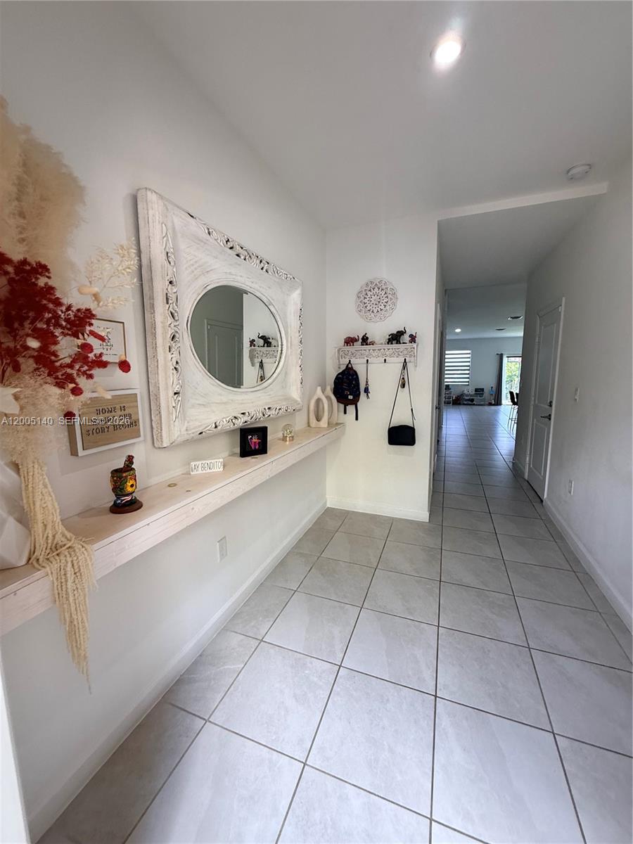 A bright entryway features a long floating shelf, a decorative mirror, and tiled flooring — 25441 SW 109th Ave, Homestead FL 33032, HOMESTEAD, FL