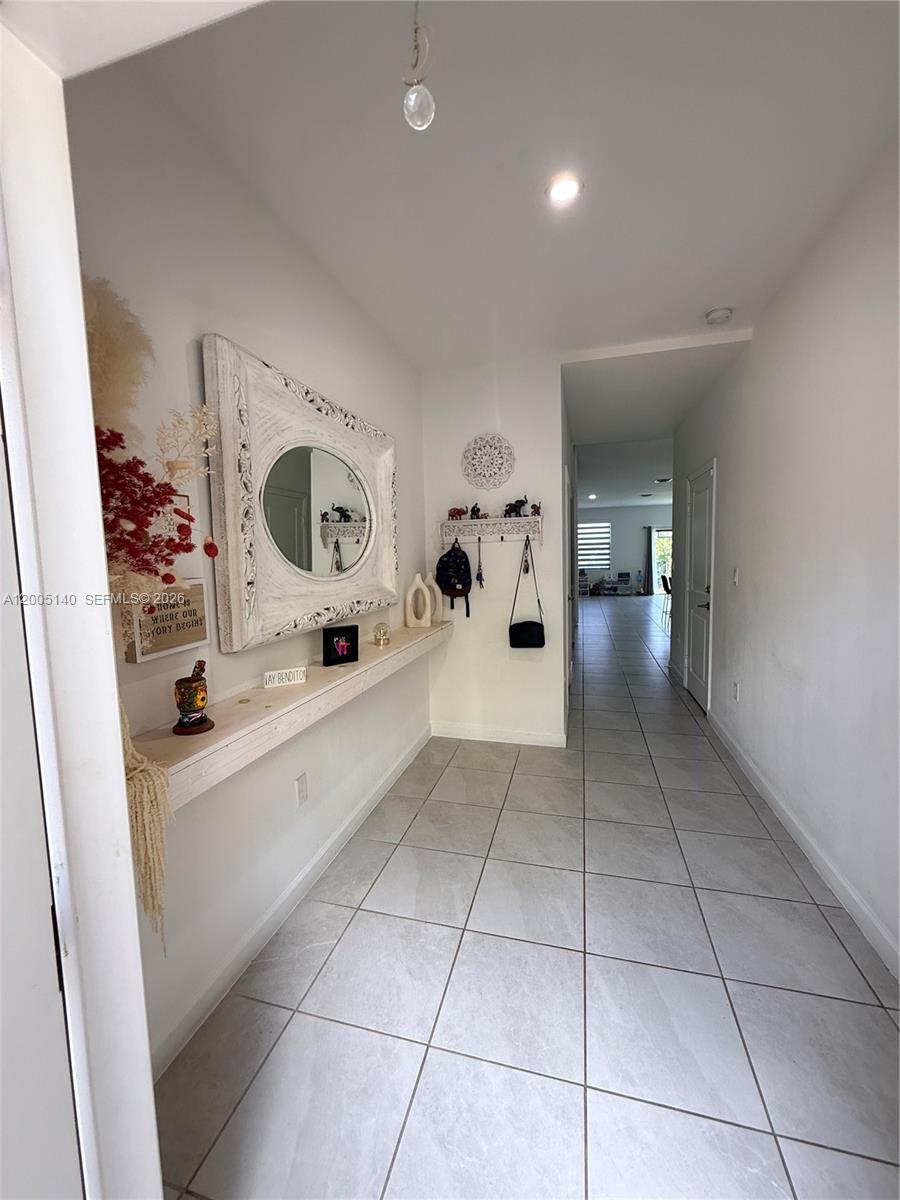 A tiled entryway features a long floating shelf, a decorative mirror, and a coat rack — 25441 SW 109th Ave, Homestead FL 33032, HOMESTEAD, FL