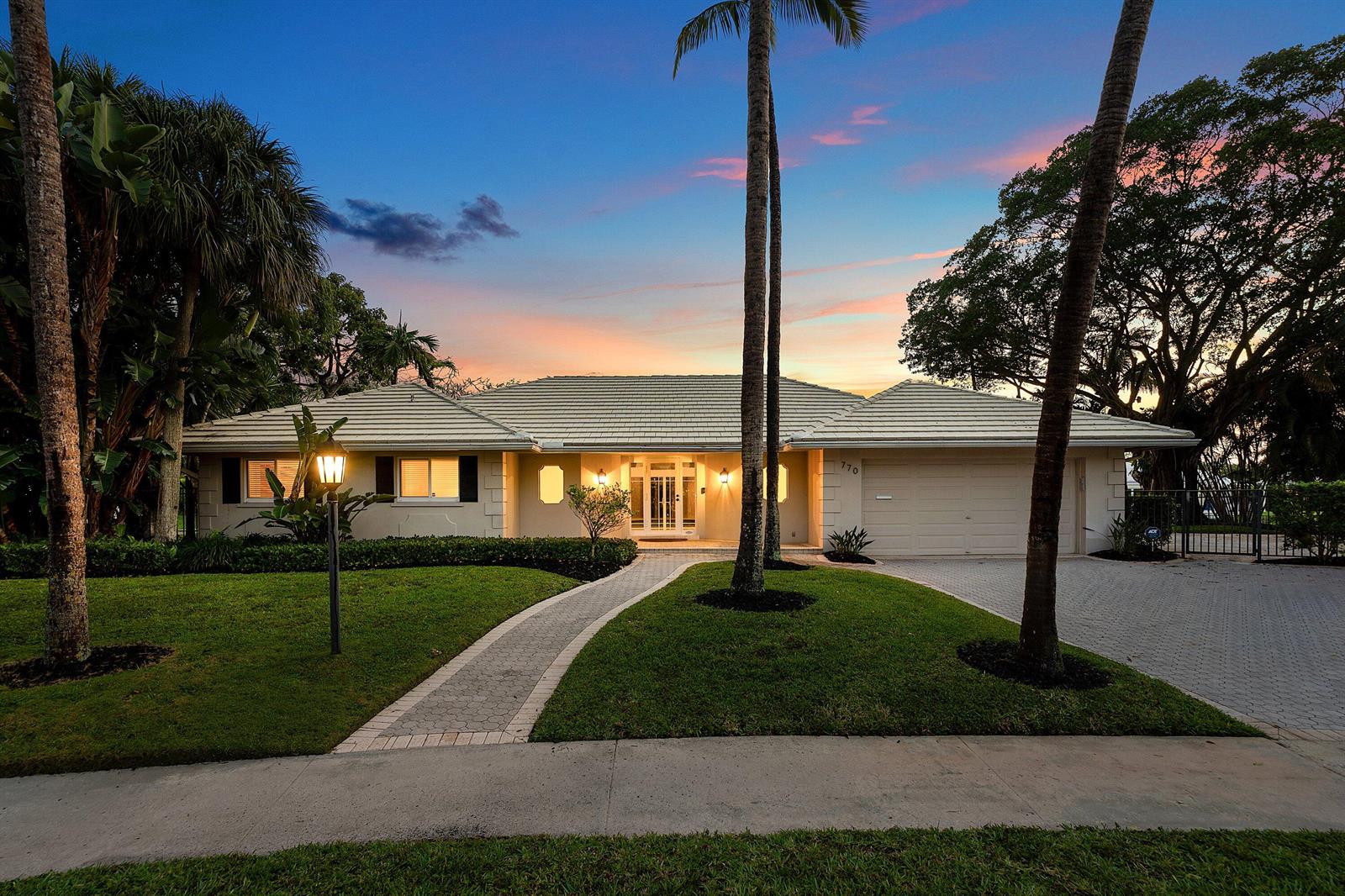 A single-story house with a tiled roof, paved driveway, and palm trees at sunset — 770 Peachtree Lane, Boca Raton FL 33486, BOCA RATON, FL