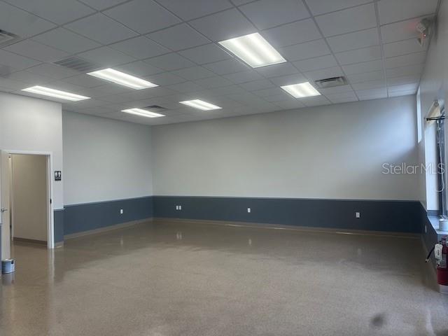 An empty commercial room features a drop ceiling, recessed lighting, and two-toned wall paint — 110 S COLLINS STREET, PLANT CITY, FL